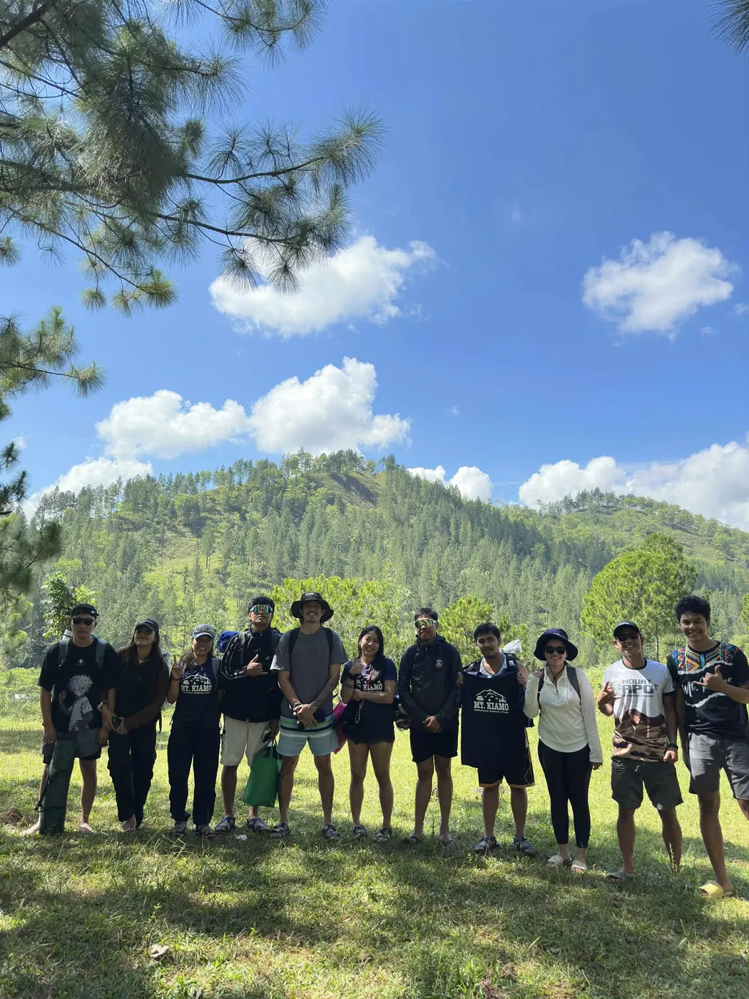 Group of hikers posing together on a grassy hillside