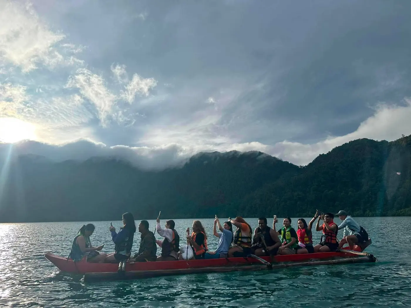 Group paddling a red canoe across Lake Holon