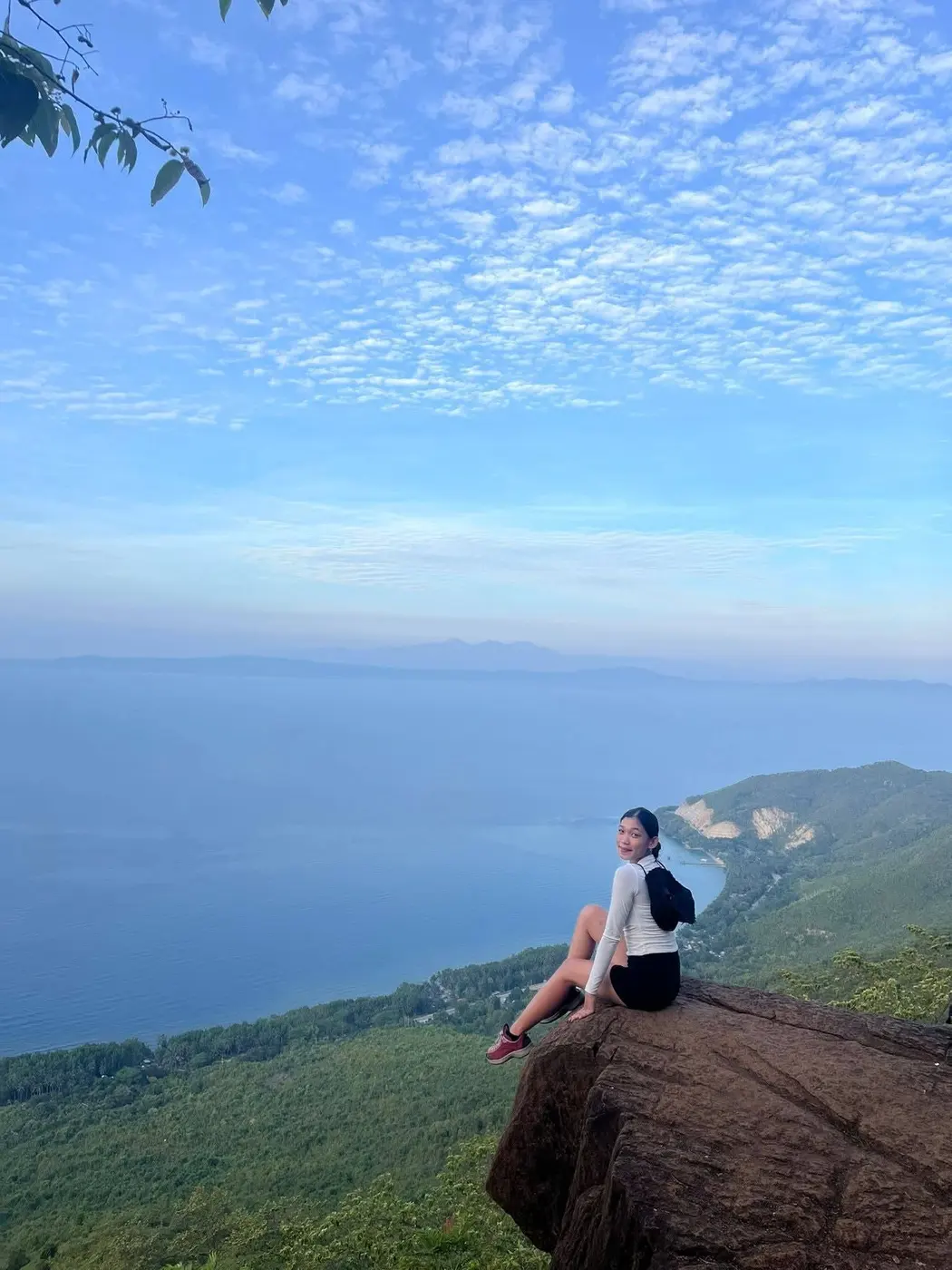 Hiker sitting on a rock above the sea